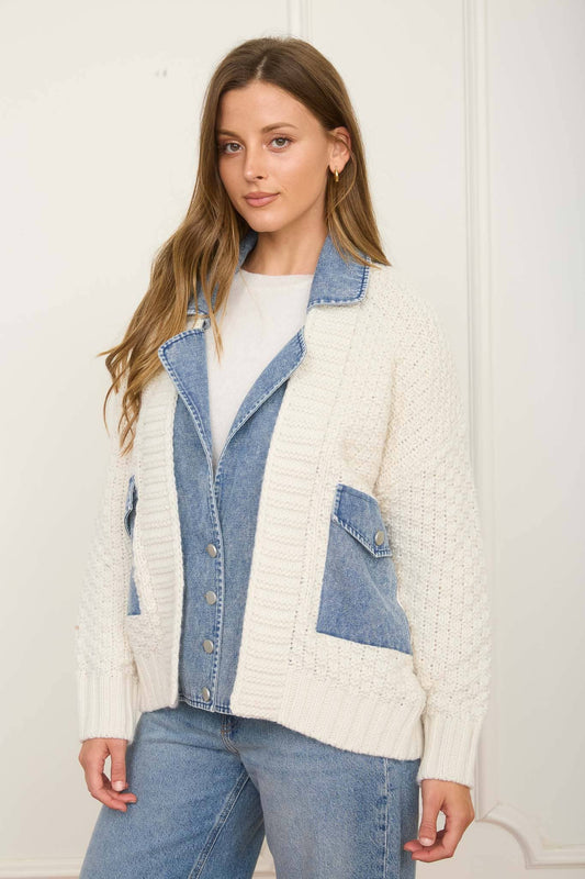 Woman wearing a white crochet jacket with denim accents against a white background